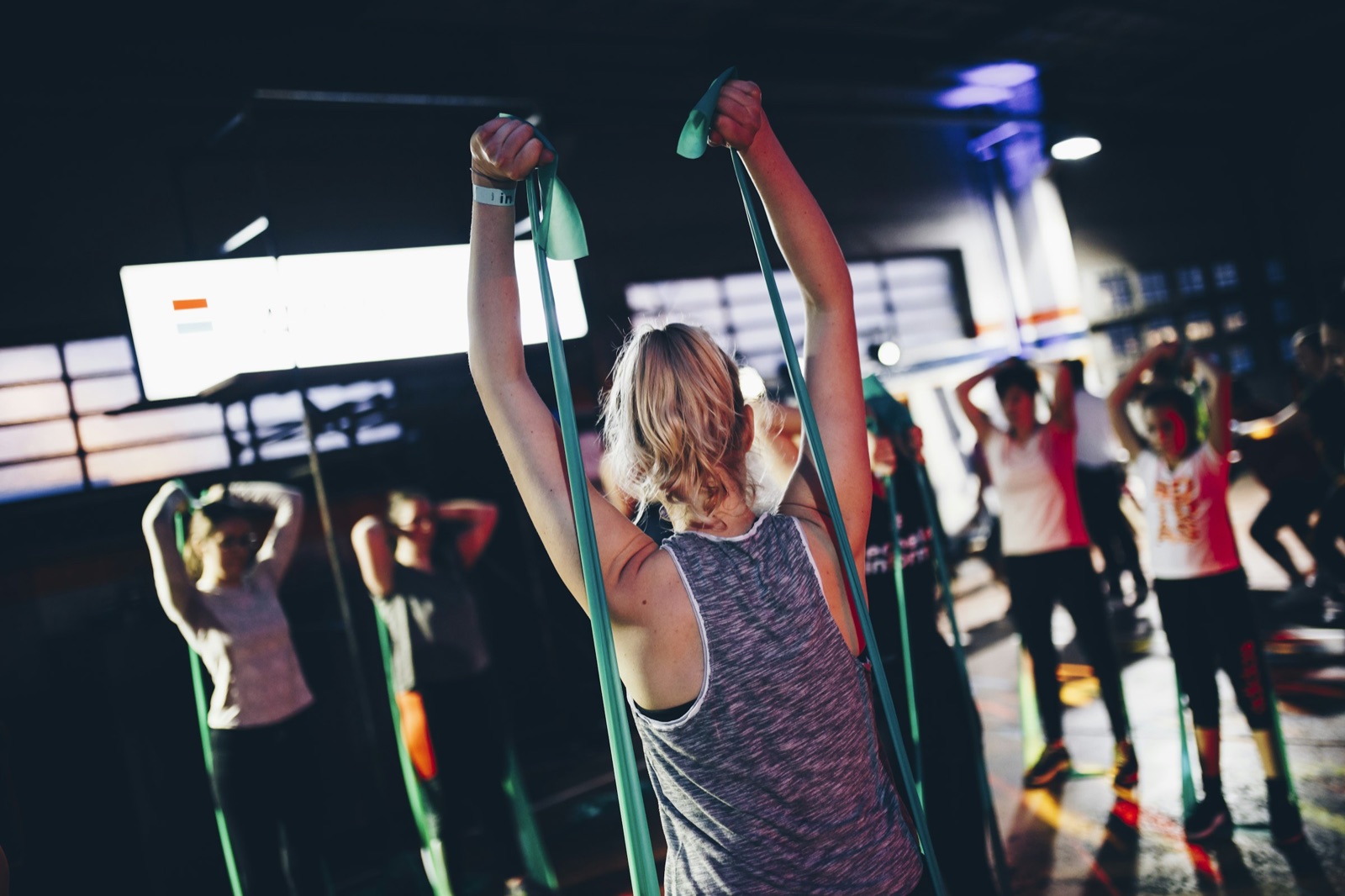 Turngruppe beim gemeinsamen Training mit Gymnastikbändern in der Halle