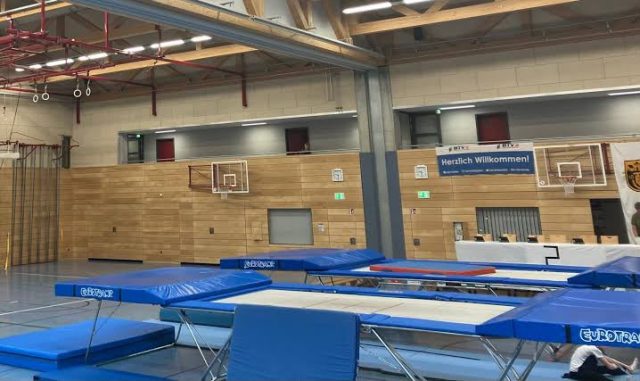 Aufgebaute Trampoline und Sicherheitsmatten in der Dreifachturnhalle, in der wir trainieren