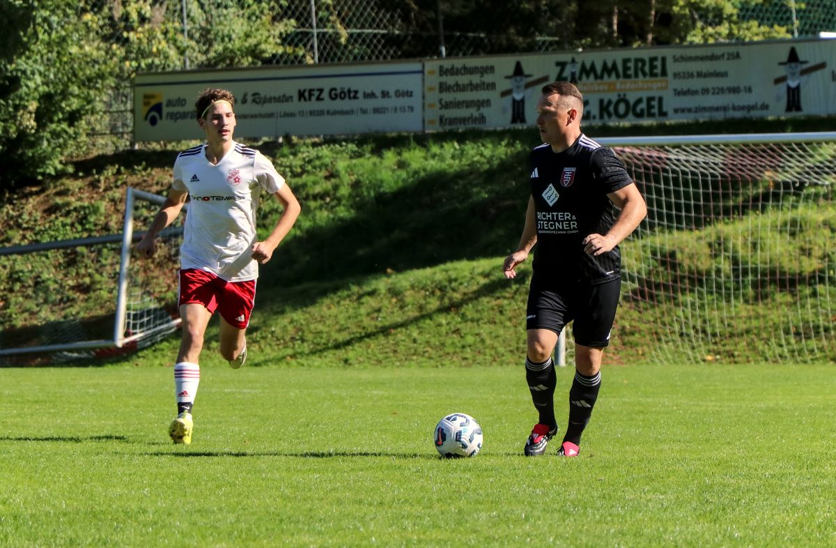 Einer unserer Spieler treibt den Ball nach vorne, ein Kirchleuser läuft heran.